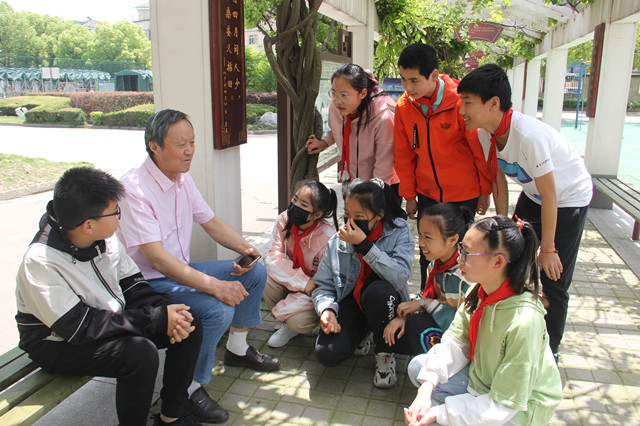 丁桂兴与德积小学六年级的学生在读书长廊聊学校的故事_副本.jpg